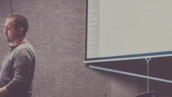 Mann steht vor einer gro&szlig;en Leinwand und pr&auml;sentiert