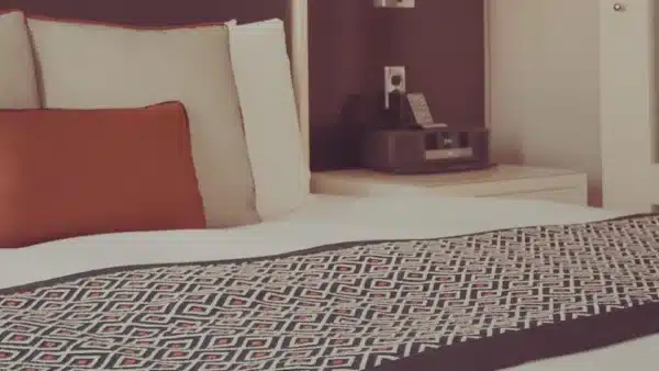 ein gem&uuml;tliches Bett mit Tagesdecke