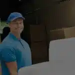 Wei&szlig;e Couch wird von zwei M&ouml;belpackern in einen LKW verladen