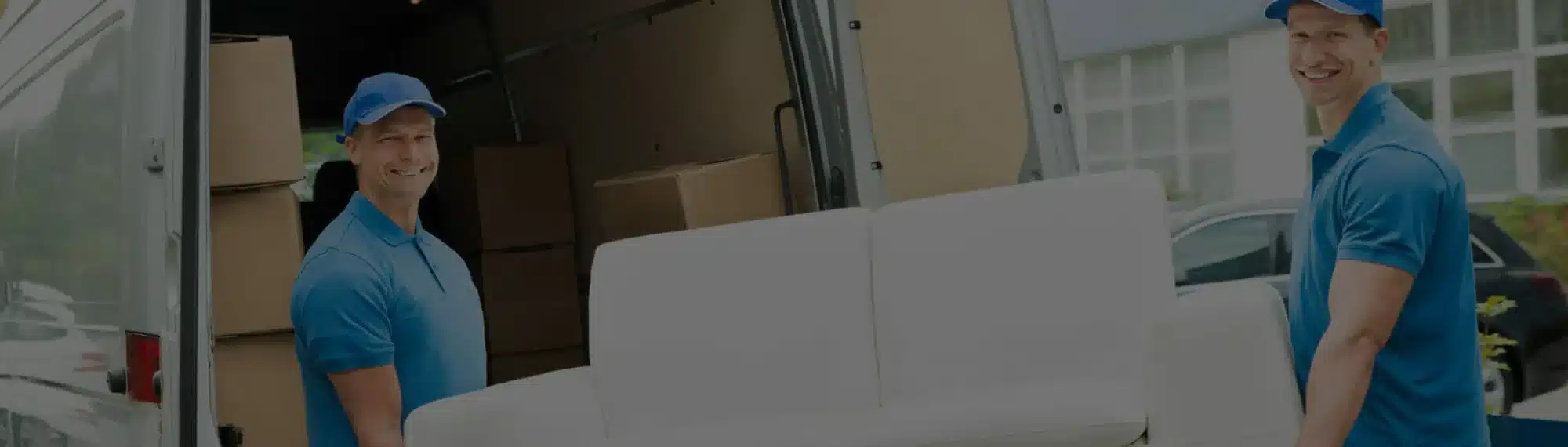 Wei&szlig;e Couch wird von zwei M&ouml;belpackern in einen LKW verladen