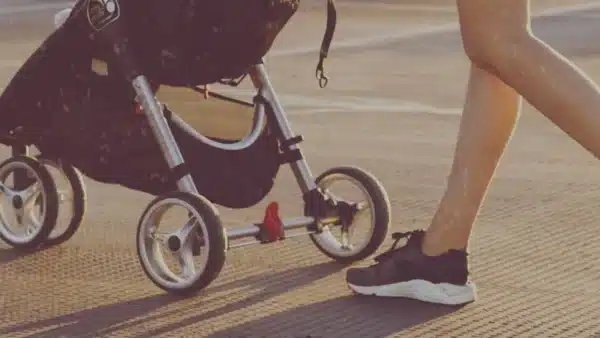 Mutti mit Kinderwagen auf der Stra&szlig;e