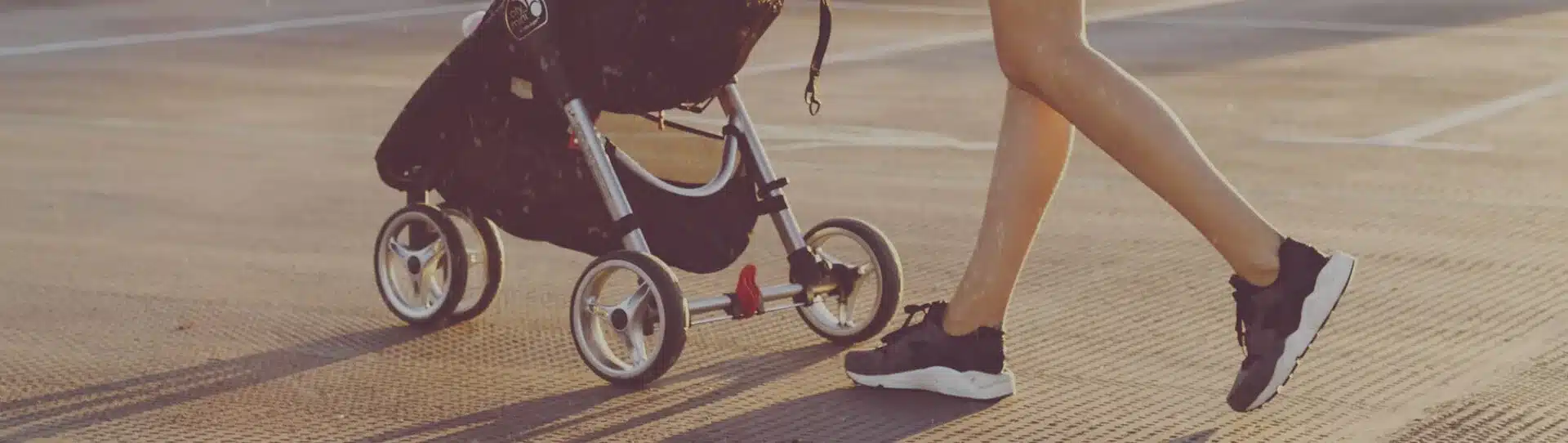 Mutti mit Kinderwagen auf der Stra&szlig;e