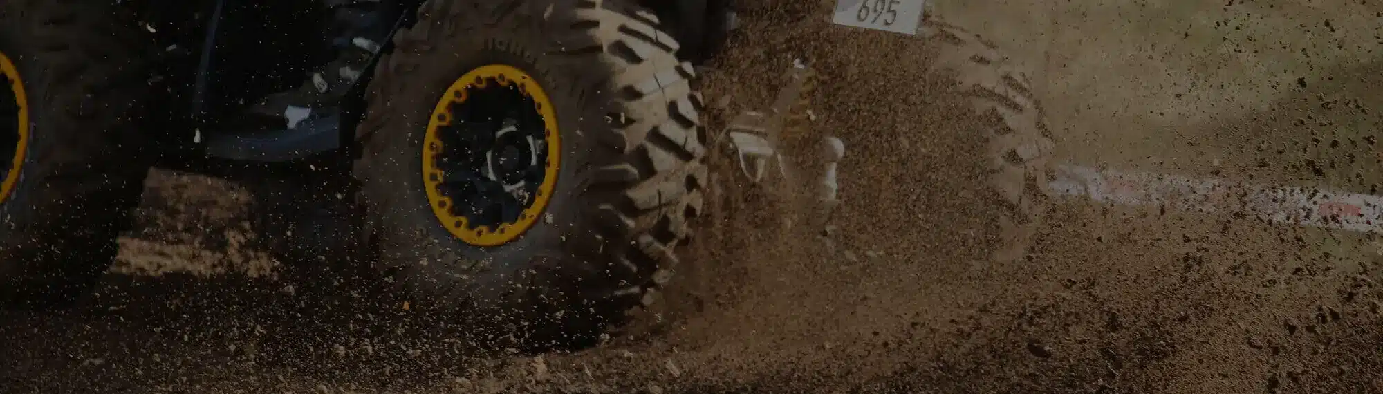 Quad f&auml;hrt schnell auf einer matschigen H&uuml;gelpiste