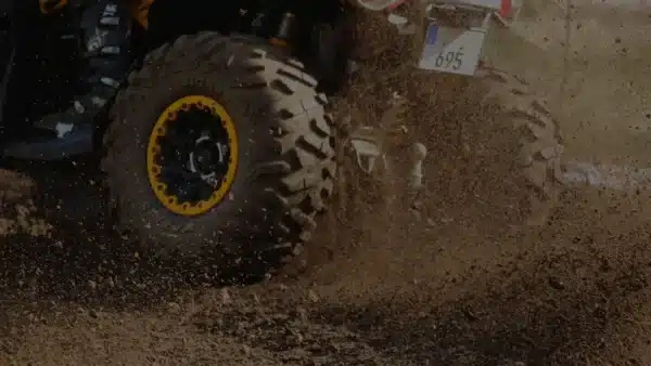 Quad f&auml;hrt schnell auf einer matschigen H&uuml;gelpiste