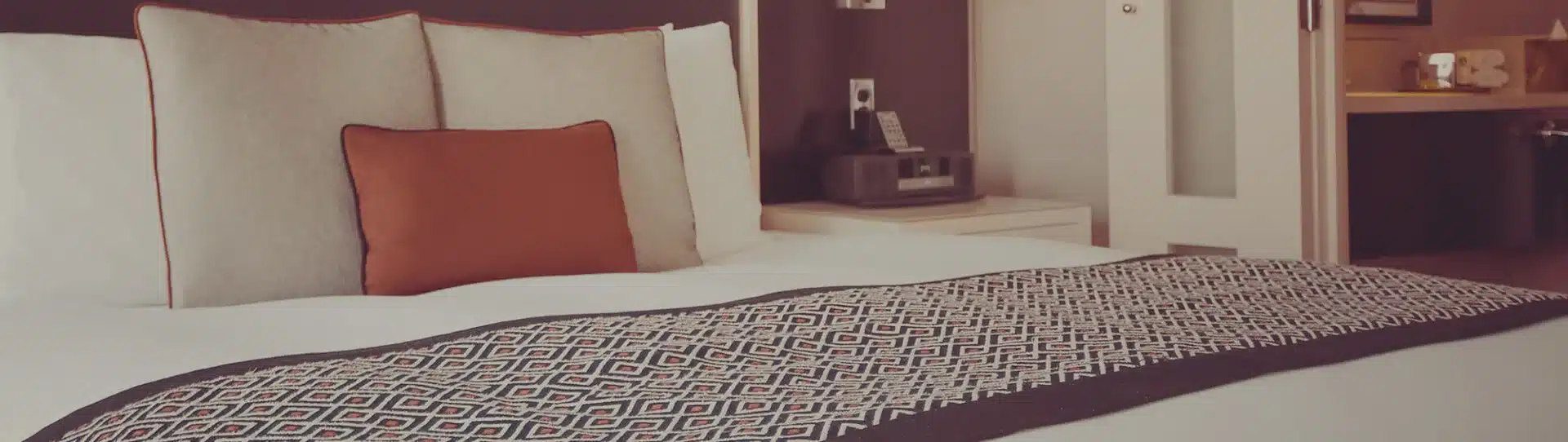 ein gemütliches Bett mit Tagesdecke