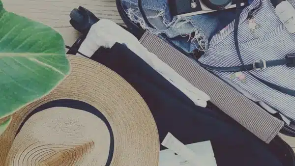 gepackter Koffer mit Hut, Kleidung bereit für den Versand