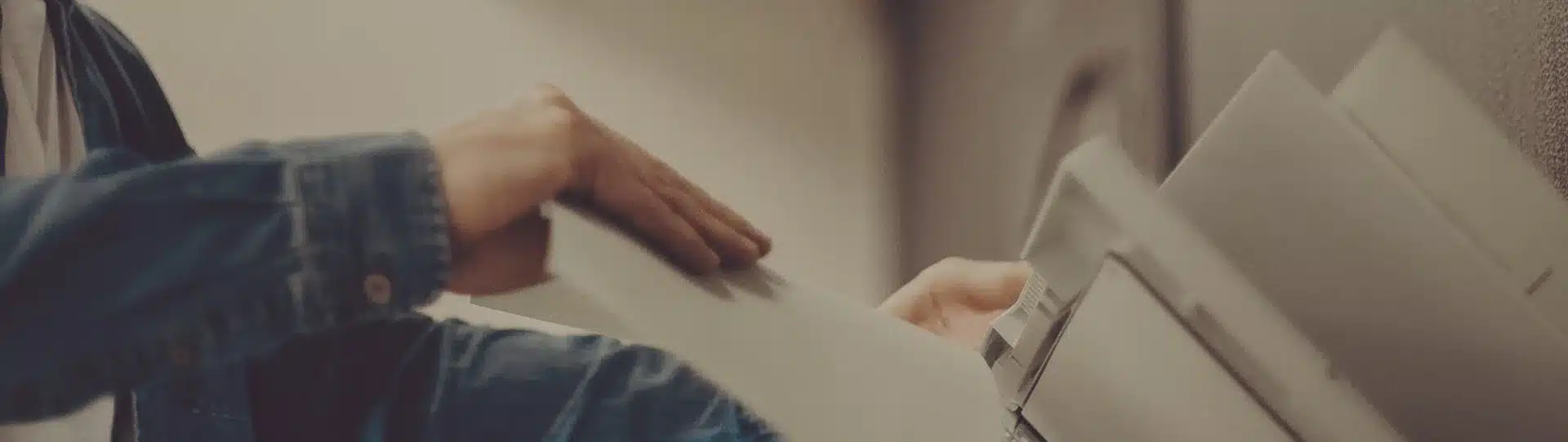 Jemand schiebt Papier in einen Drucker